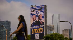 A woman walks past a Likud Party campaign billboard featuring President Trump and Israeli Prime Minister Benjamin Netanyahu, with a Hebrew message reading, "We have one opportunity to win," in Tel Aviv, Israel, on Monday.