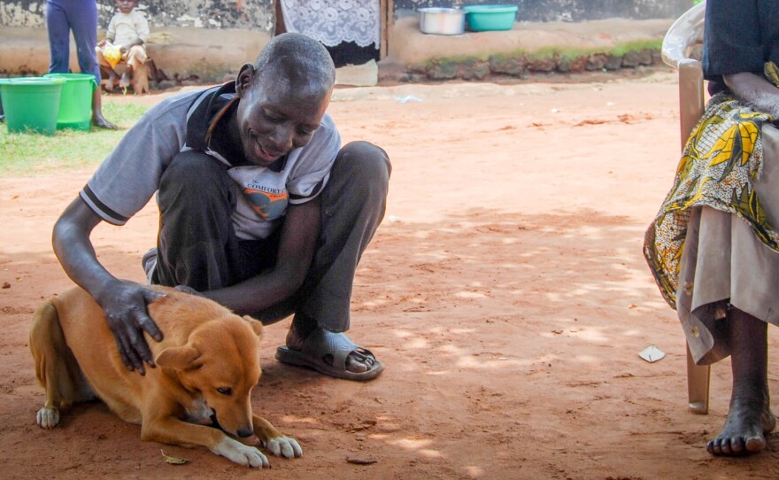 Watmon and Ogen Rwot sit next to his mother in the yard of his family's compound.