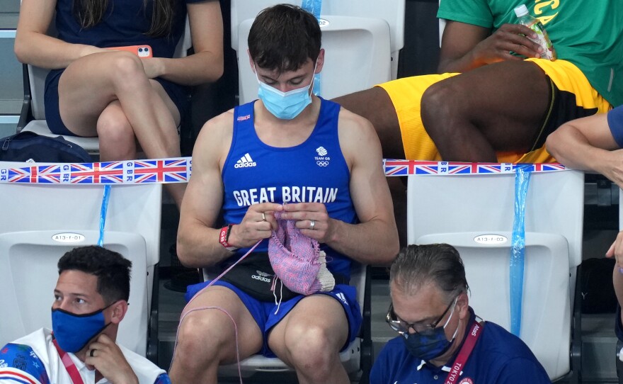 Great Britain's Tom Daley knits in the stands during the Women's 3m Springboard Final at the Tokyo Aquatics Centre on the ninth day of the Tokyo 2020 Olympic Games in Japan.