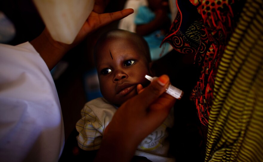 At the health clinic in Minjibir, two drops of vaccine are dropped into a child's mouth during a 2012 campaign.