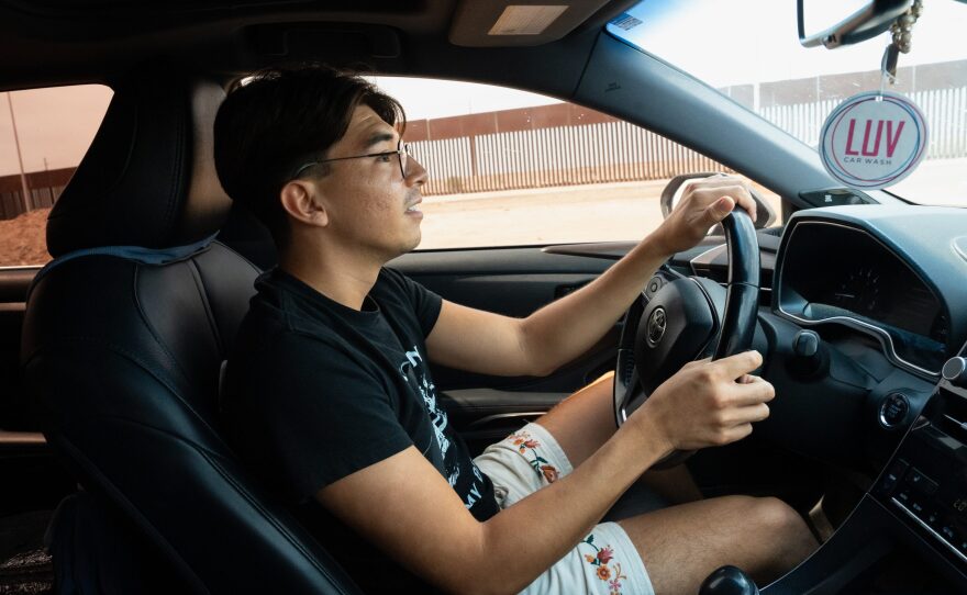 Bryan Vega drives along the border wall on his way back to Holtville from his doctor's appointment in Mexicali on Aug. 6, 2024.
