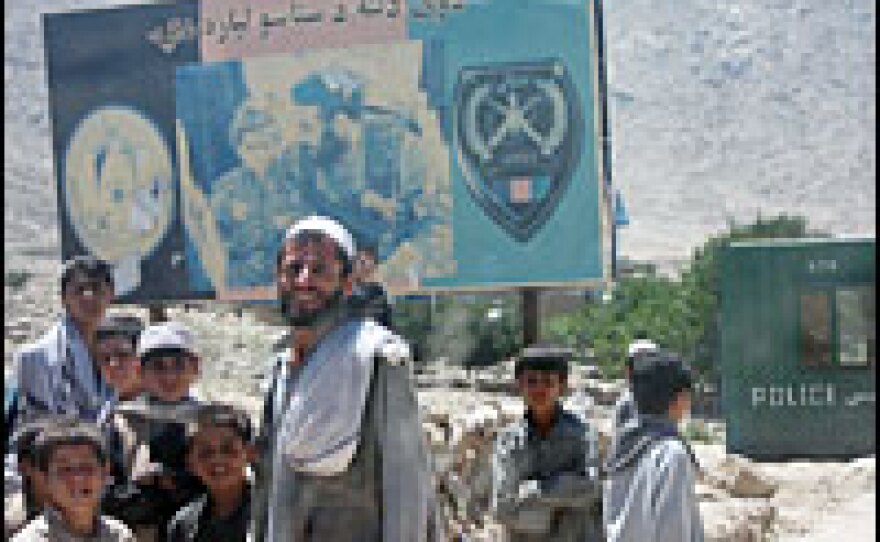 Villagers in Elisay stand near a green container that will serve as a checkpoint. The checkpoint was set up by the American military and Afghan National Police moments earlier.