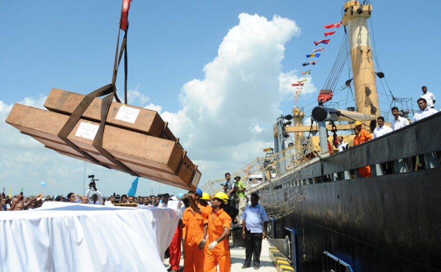 Workers unload cargo from the first vessel to enter the Chinese-funded port in Hambantota, Sri Lanka, in November 2010. China's Export-Import Bank provided 85 percent of the financing for construction of the port.