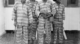 Historical photo of four convict laborers in shackles. 