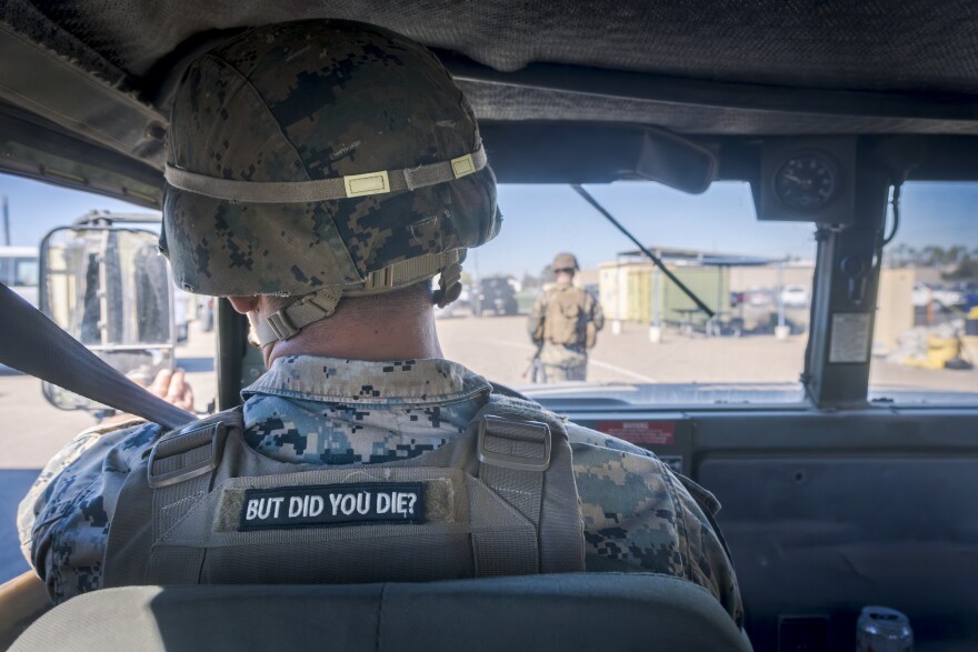 A Marine drives a Humvee at Marine Corps Air Station Miramar during a training exercise. The patch on the back of his ballistic vest says “But did you die?” Oct. 22, 2024.