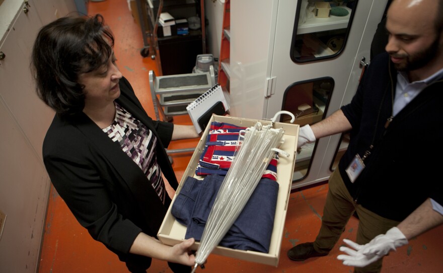 Vales Hilbig (left), Deputy Director of Communications and Marketing at the National Museum of American History, passes along clothing that represents the spirit of campaigning in the 70's to curator Jon Grinspan.