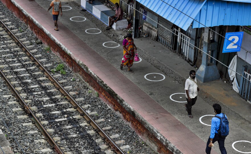 People walk through a railway station platform marked with circles to maintain physical distance in Kolkata, India, Monday. India's increasing coronavirus caseload made it the pandemic's second-worst-hit country behind the United States.