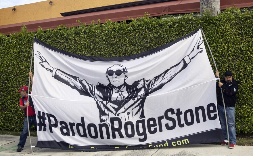 Activists display a sign in support of Stone as President Trump's motorcade heads to Palm Beach International Airport in March in West Palm Beach, Fla.