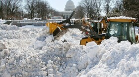 A front end loader piles up snow that was trucked in from Senate parking lots at the U.S. Capitol on February 8, 2010 in Washington, DC. 