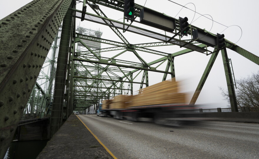 In this file photo, a logging truck drives on the Interstate 5 bridge that spans the Columbia River and connects Portland, Ore., with southwest Washington state, part of the 3rd Congressional District, on Feb. 13, 2024.