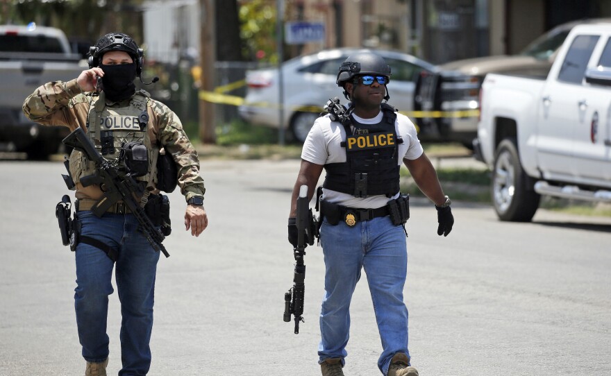 Police walk near Robb Elementary School following a shooting.