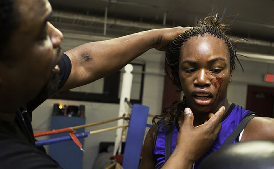 Jason Crutchfield, Claressa's coach, examines her after a sparring session at Berston Field House in Flint, Michigan. Claressa trained at Berston from age 11 to 17. When she was 13, and before it was announced that women would be allowed to box in the Olympics, Crutchfield predicted she would win the Olympic gold.