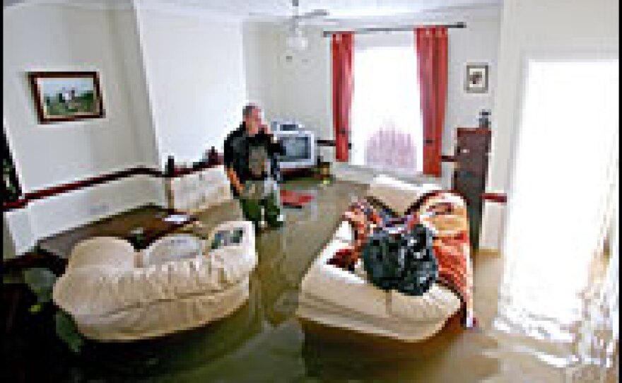 Gloucester resident Norman Aitken walks through his home which was severely flooded when the river Severn burst its banks due to heavy rainfall. Flooding has left thousands of homes unliveable.