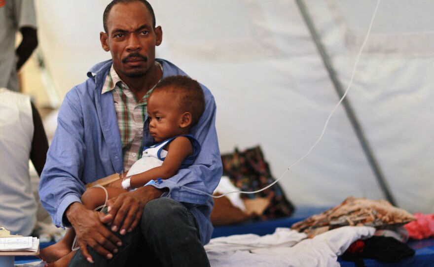 Theophil Gilot holds his son, Alexendro Gilot, who is treated for cholera in a facility in Cabaret, Haiti, on Nov. 24, 2010. In December 2016, then-U.N. Secretary-General Ban Ki-moon apologized for the U.N.'s role in a cholera outbreak, saying peacekeepers were the most likely source.