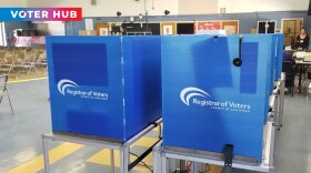 Voting booths are spread out inside a vote center in La Mesa Arts Academy, June 7, 2022 with KPBS Voter Hub overlay.