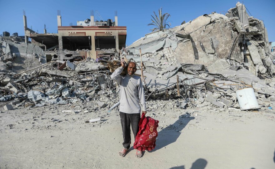 People inspect damage and remove items from their homes following Israeli airstrikes on April 7, in Khan Yunis, Gaza.