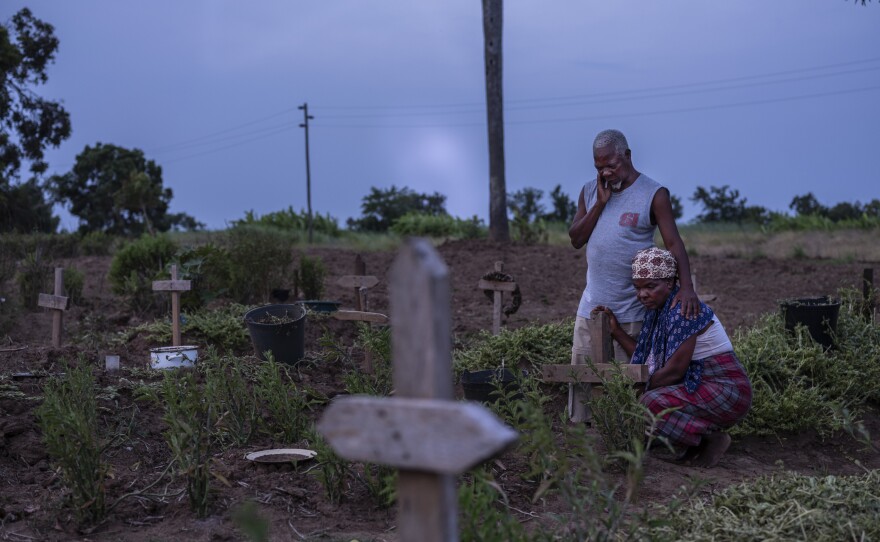 Siblings Luis Chopace and Mariamo Chopace at the grave of their sister Sumbo Chopace, who was killed when her home collapsed during Cyclone Idai. Mozambique's government is struggling to make the country more resilient in response to extreme weather.