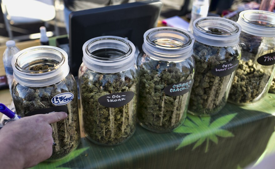 A vendor points to a selection of cannabis strains for sale during a 2018 marijuana festival in California.