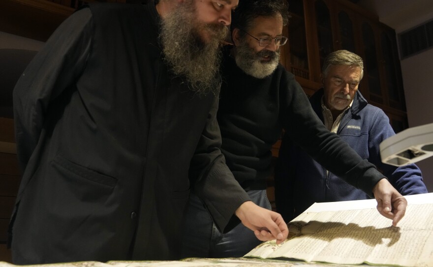 Father Theophilos, a Pantokrator monk, left, checks a manuscript at the library of Pantokrator Monastery in the Mount Athos, northern Greece, on Thursday, Oct. 13, 2022.