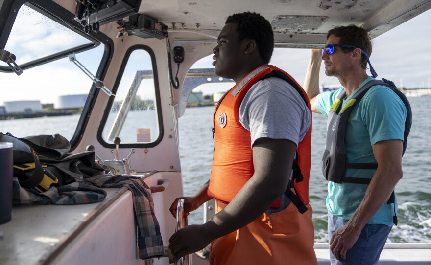 Cris is guided by Luke Holden while steering Sea Smoke.
