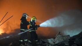 In this photo released by Xinhua News Agency, firefighters work to out the fire after an explosion at a fireworks plant in Guandu Town of Liuyang, central China's Hunan Province, in the early hours of May 5, 2026.