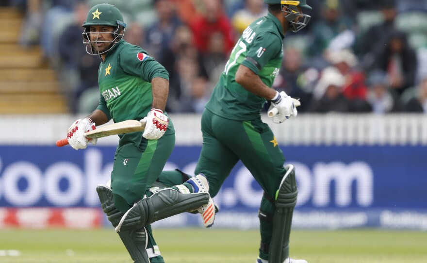 Pakistan's captain Sarfaraz Ahmed (left) passes teammate Wahab Riaz during the Cricket World Cup match between Australia and Pakistan in Taunton, England, on Wednesday.