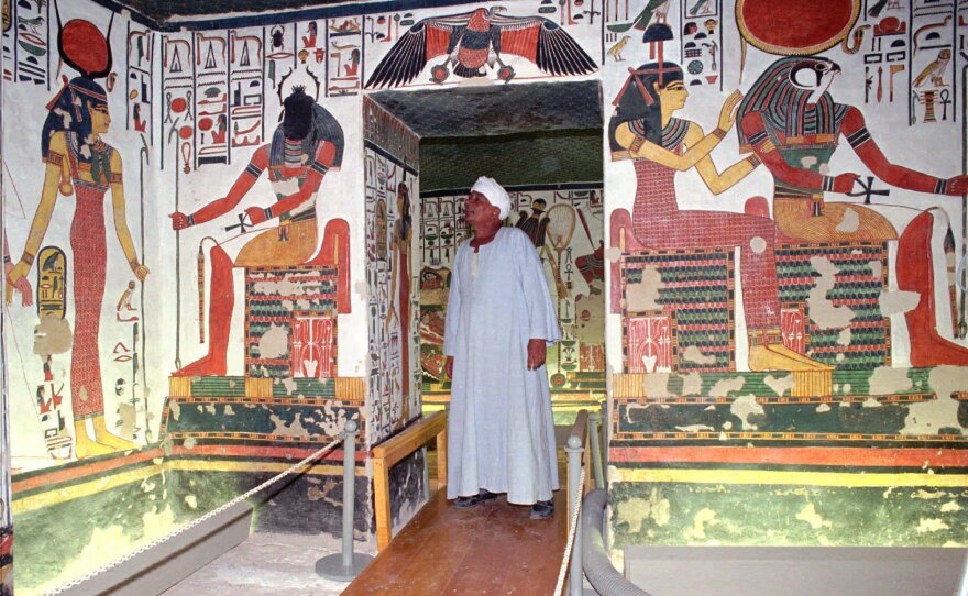 An Egyptian guard examines a doorway inside the tomb of Queen Nefertari in the Valley of Queens in Luxor, south of Cairo, in 1995.
