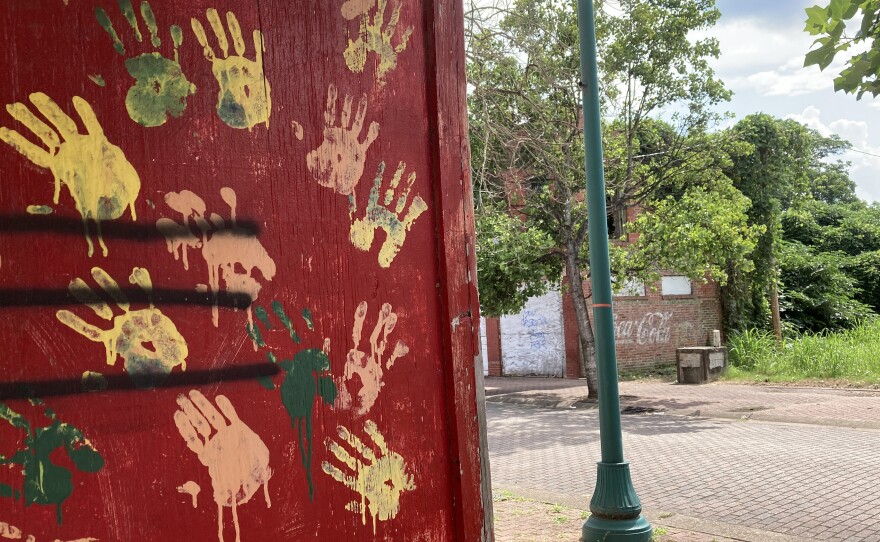 Handprints mark one of the boarded up buildings on Farish Street. Some lots on the street have been overtaken by weeds.