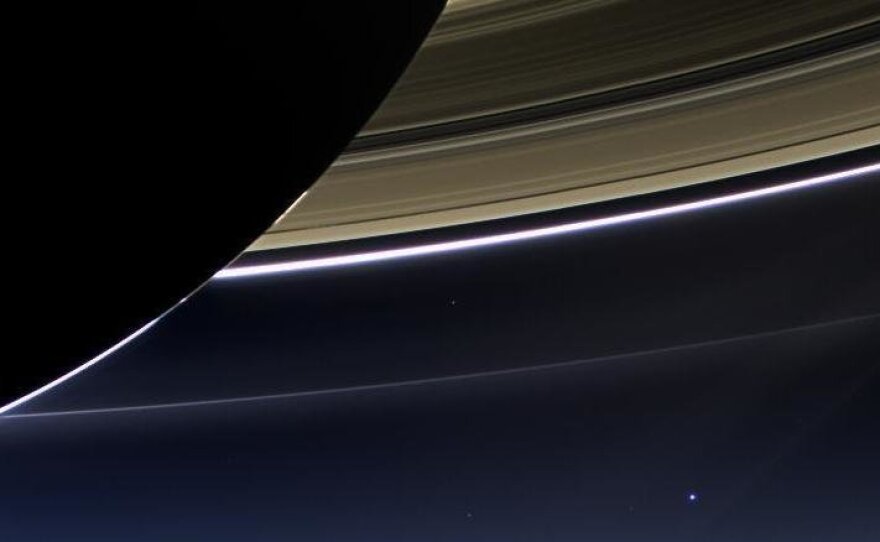 An image taken on July 19, 2013, by the wide-angle camera on NASA's Cassini spacecraft captured Saturn, its rings and our planet Earth, which is the tiny dot in the lower right.