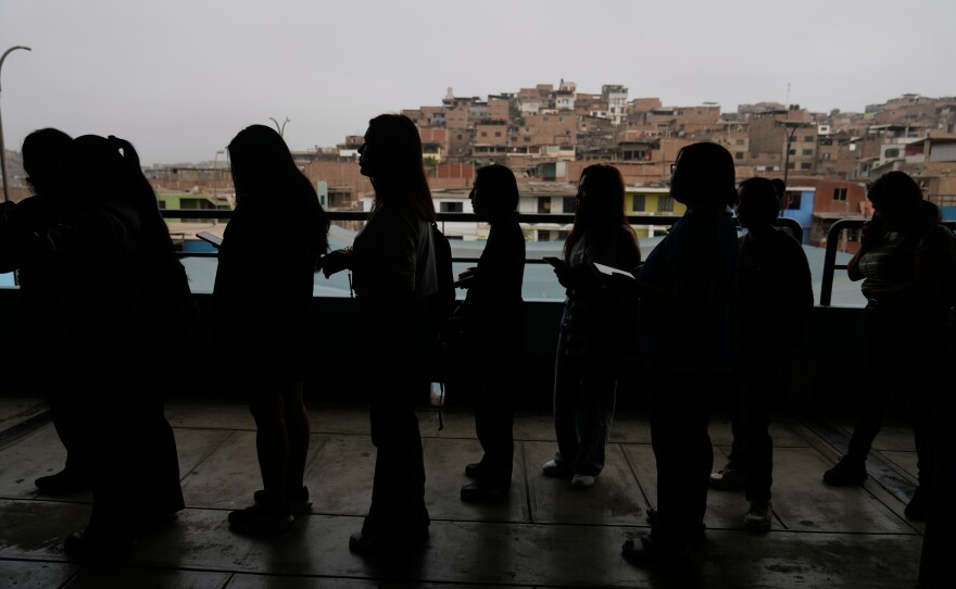 Voters line up as voting resumes at a polling stations affected by delays during general elections in Lima, Peru, Monday, April 13, 2026.