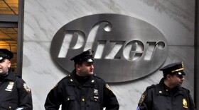 Police officers stand in front of Pfizer's New York City headquarters during an Occupy Wall Street march, Feb. 29, 2012.