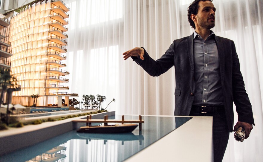 Simon Koster of JDS Development Group points to a model of the Monad Terrace luxury development, which is being built with climate change in mind.