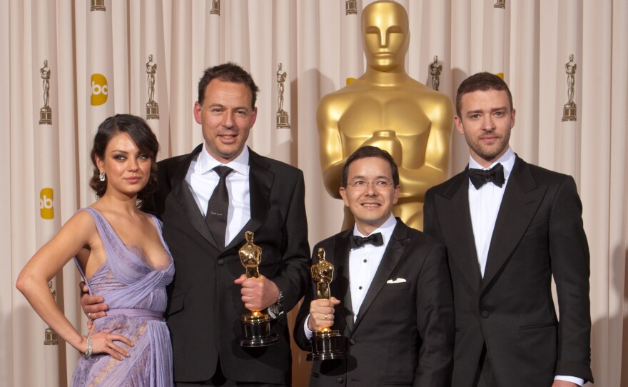 Mila Kunis and Justin Timberlake flank the Best Animated Short winners Shaun Tan and Andrew Ruhemann.