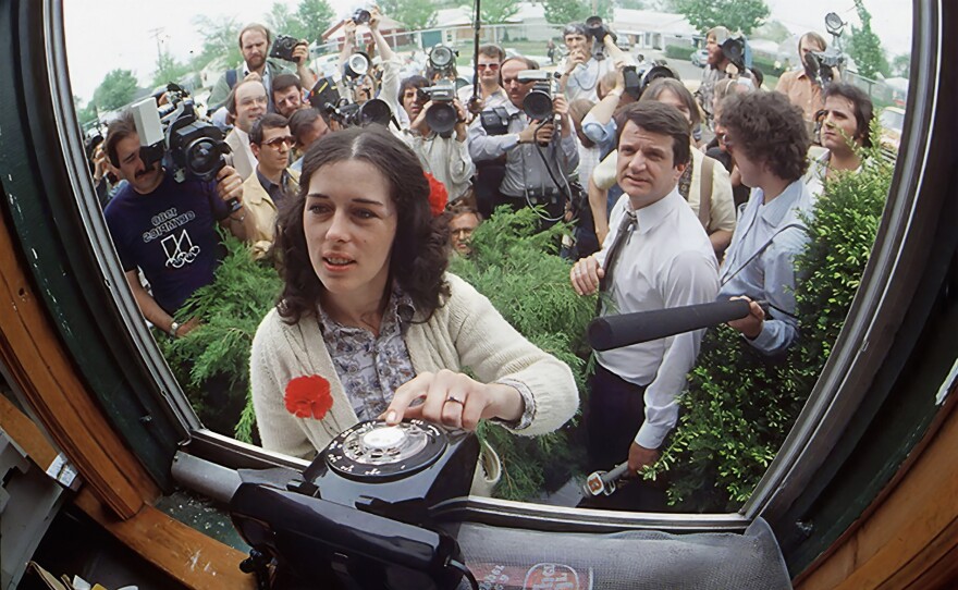 Surrounded by media, Lois Gibbs waits outside the Love Canal Homeowners Association for a phone call from the White House. May 1980.