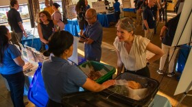 An attendee listens during an open house meeting about San Diego trash collection services at the La Jolla-Riford Library on Sept. 9, 2024.