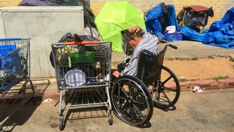 A man sits in a wheelchair near homeless encampments on 17th Street in San Diego's East Village, July 6, 2017.