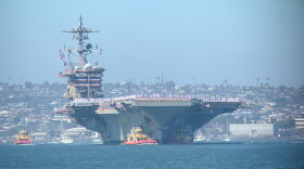 Tug boats maneuver the USS Abraham Lincoln into its dock on Naval Air Station North Island on Oct. 8, 2026. The Lincoln returned from a 10-month extended deployment to the Middle East.
