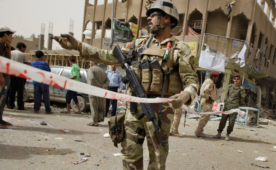 Iraqi security forces secure the scene where a blast killed seven people in Baghdad's Hurriya neighborhood, about 500 yards from a polling station. A string of blasts across the capital killed 17 people Thursday, ratcheting up fear in an already tense city as many Iraqis cast early ballots ahead of Sunday's elections.