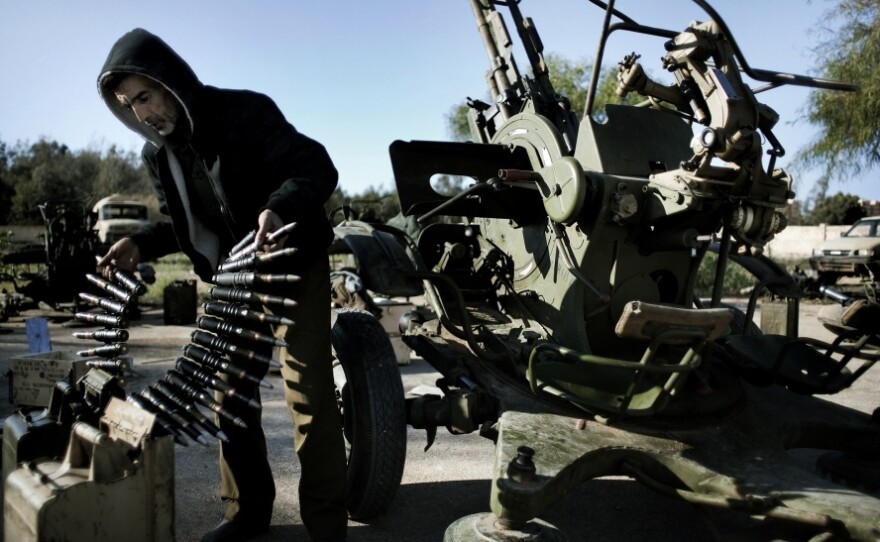A Libyan civilian holds anti-aircraft ammunition at an army barracks in Benghazi, where dozens of civilians registered for civil defense  training amid fears of air raids from Tripoli.