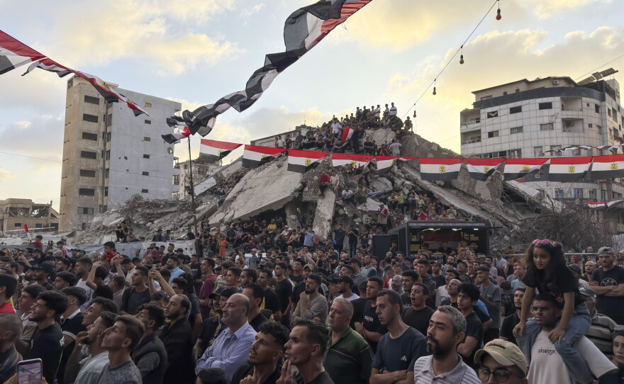 Thousands of displaced Palestinians gather under Egyptian flags amid the rubble in Gaza City for a public screening of Egypt's match against Argentina in the World Cup on July 7, 2026.