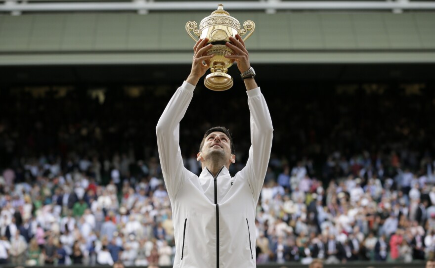 Novak Djokovic celebrates after defeating Roger Federer in the men's singles final match of the Wimbledon Tennis Championships in London.