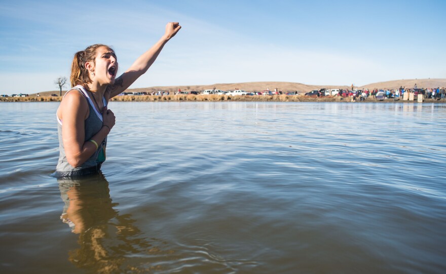 Stephanie Jasper holds up her fist and yells while protesting in the Cannonball River during a standoff with police at Turtle Island, north of the Standing Rock Sioux Reservation.