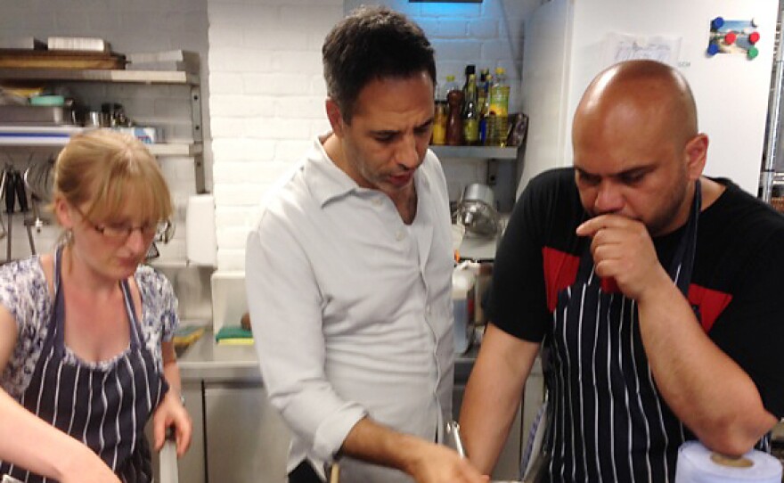 From left: Recipe developer Esme Robinson, chef-owner Yotam Ottolenghi and Nopi head chef Ramael Scully hover over the electric stovetop while preparing a dessert in the Ottolenghi test kitchen in London.