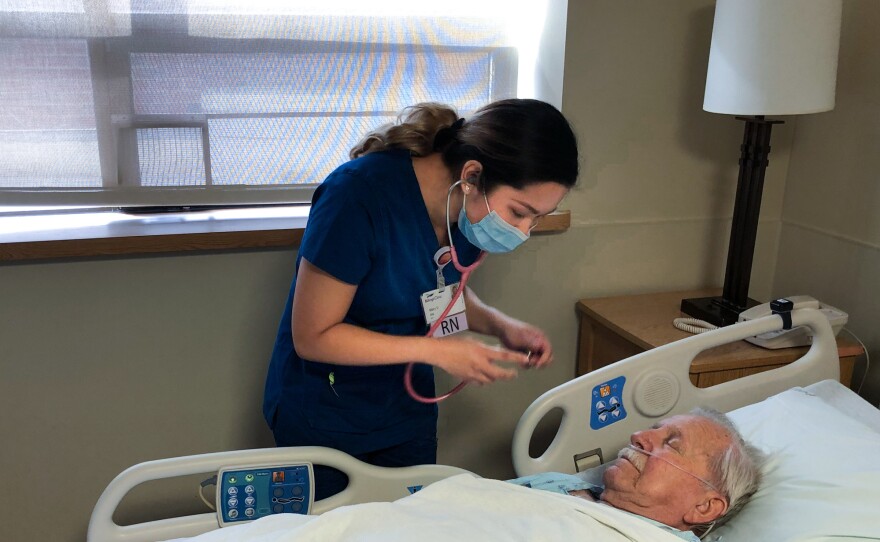 Mary Venus, a nurse from the Philippines, checks on a patient inside the in-patient surgical recovery unit at Billings Clinic in Billings, Mont.