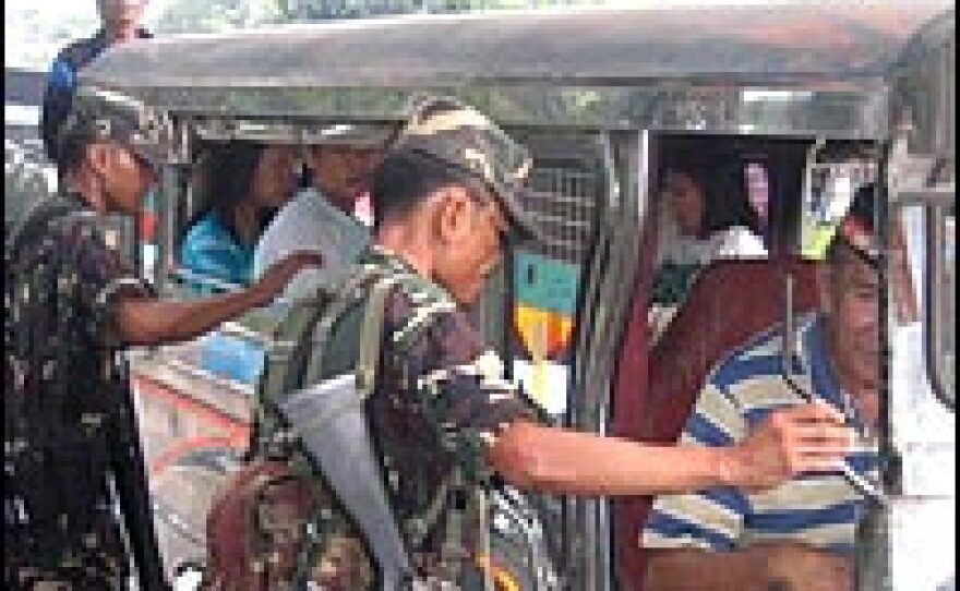 Philippine Army troops man a roadblock outside Zamboanga, on the southern island of Mindanao, checking vehicles for guns and explosives.