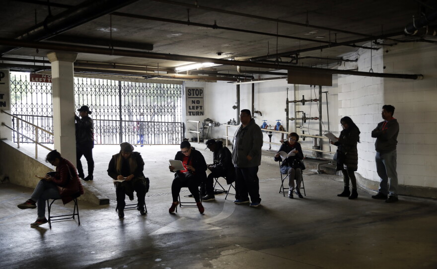 Hospitality workers wait in line to apply for unemployment benefits at the outset of the COVID-19 pandemic in March 2020.