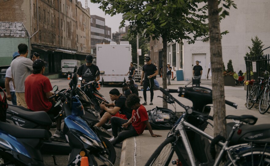 Unable to obtain legal employment, some residents work as delivery drivers in Brooklyn.