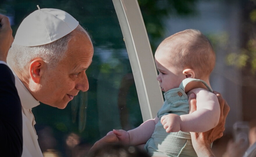 Pope Leo XIV greets a child upon arriving in the popemobile at Plaza de Cibeles for a Holy Mass and Corpus Christi procession in Madrid, Spain, Sunday, June 7, 2026, on the second day of his seven-day apostolic visit to mainland Spain and the Canary Islands.