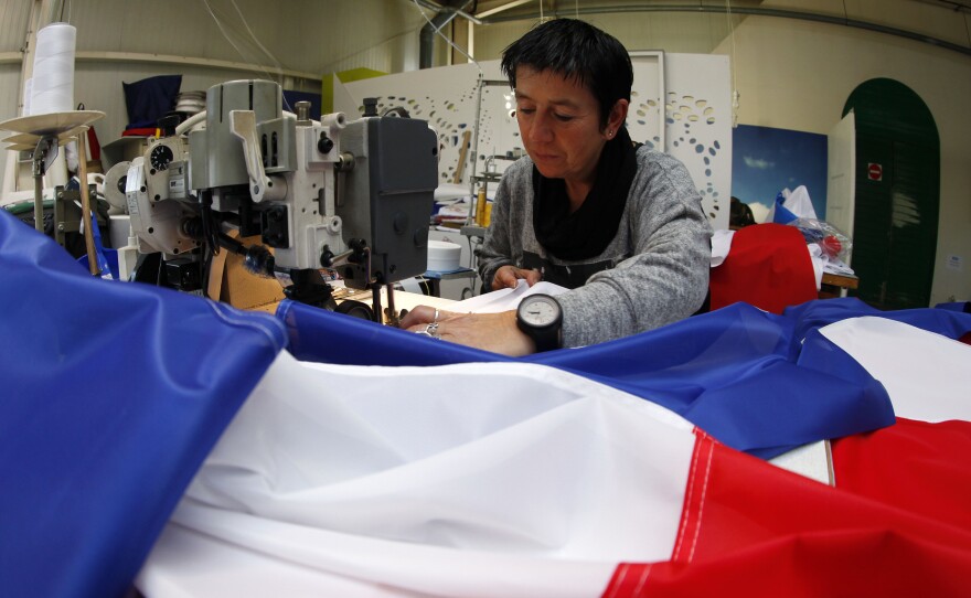 Michelle Houste sews a French flag at a factory near Lille, northern France on Thursday. There's been a surge in the demand for French flags since the Nov. 13 attacks in Paris.