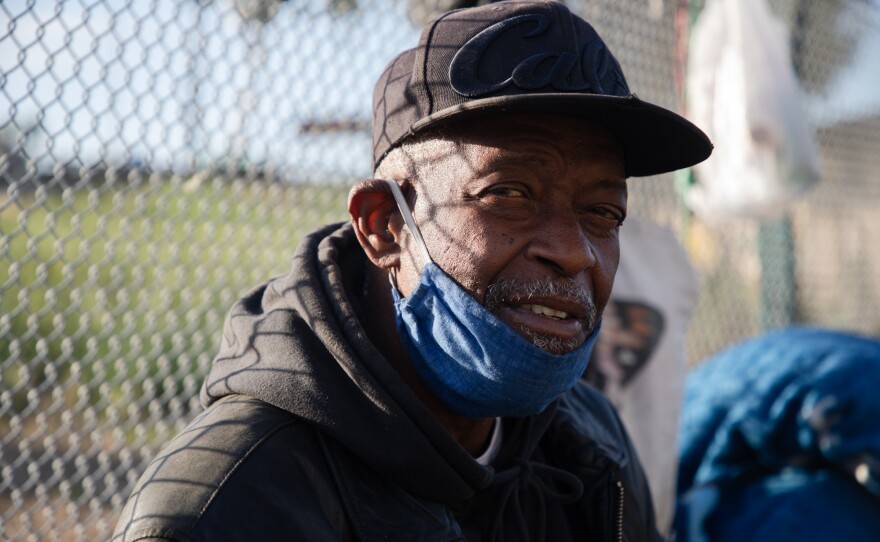 Vernon Wellington sits with his belongings while cooking breakfast on 17th Street in San Diego, May 20, 2020.